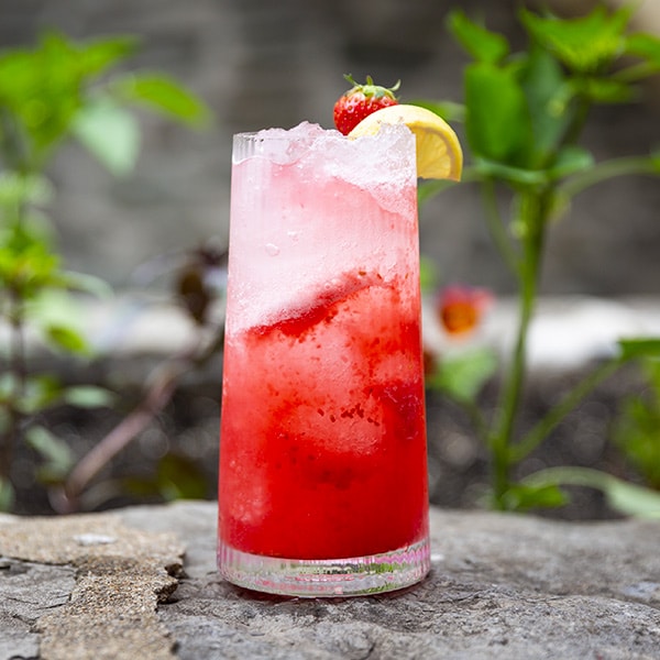 Cockail à base de fraise dans un grand verre sur un des murets de la cour intérieure du Musée