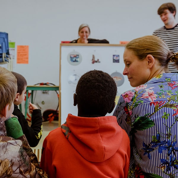 Photo d'une femme et de deux enfants, de dos, en train de participer à l'activité de médiation éducative Ricochet