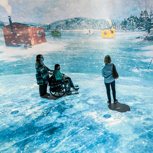 Des enfants jouent avec les poissons sur le lac virtuel dans l'expoaition Histoire de pêche.